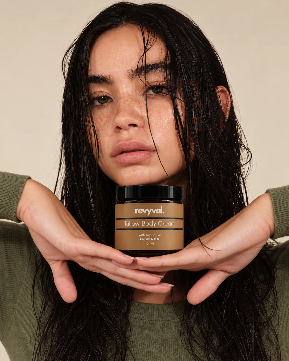 A woman holding a Revyval Tallow Body Cream jar